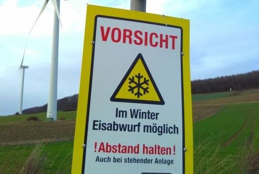 Schild am Windrad: "Vorsicht! Eisabwurf möglich"
