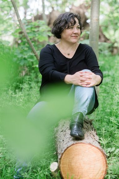 Portrait: Katja auf einem Baumstamm