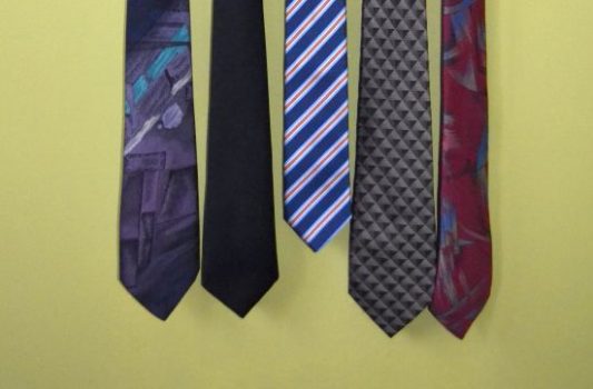 Fünf Krawatten hängen nebeneinander